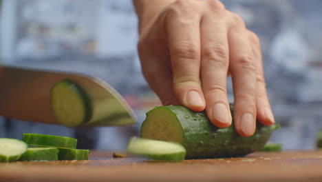 Cut-a-knife-on-a-wooden-board-closeup-cucumbers-in-the-kitchen.-shred